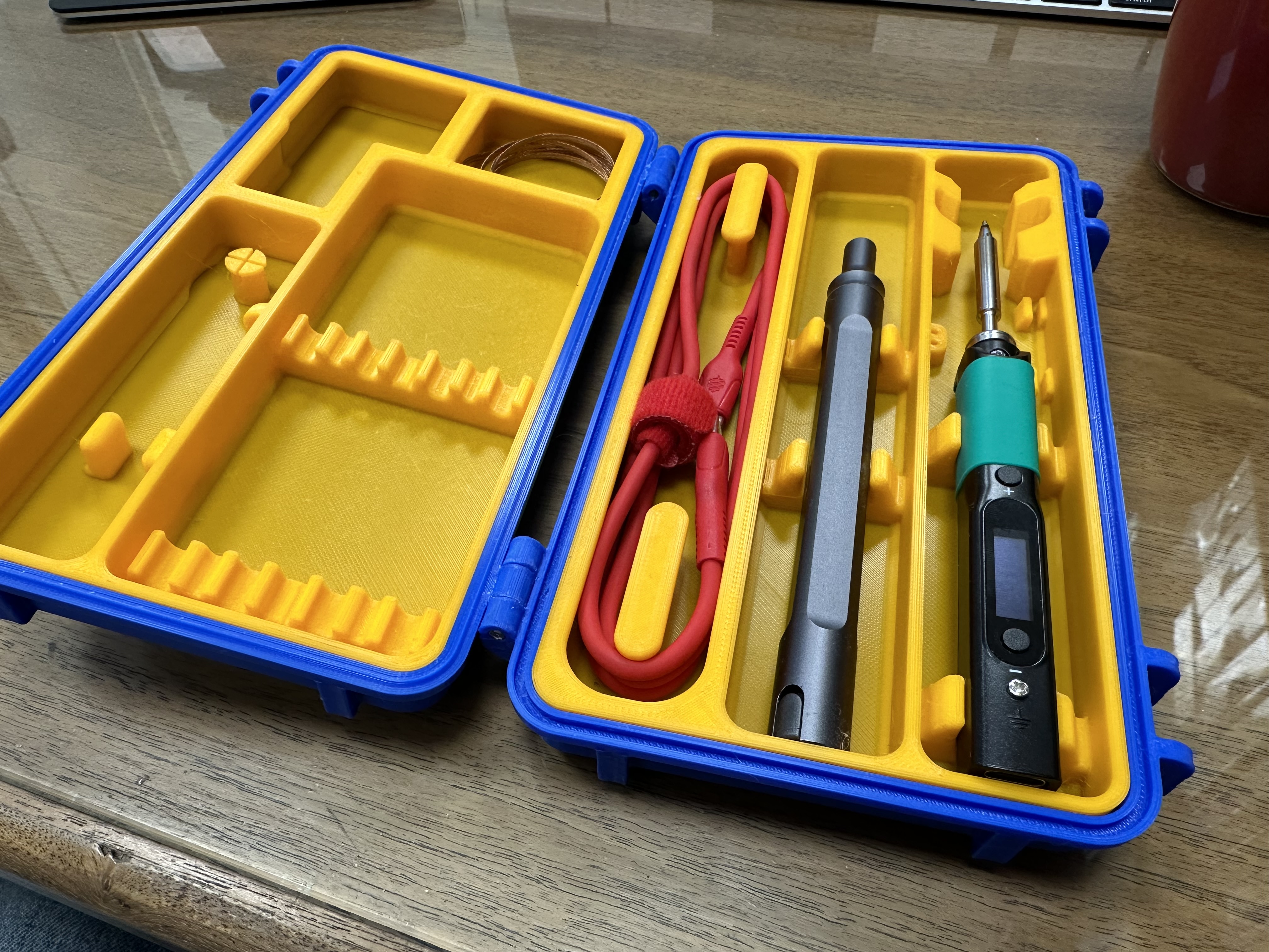 A Pinecil travel case 3D printed in blue and yellow PLA